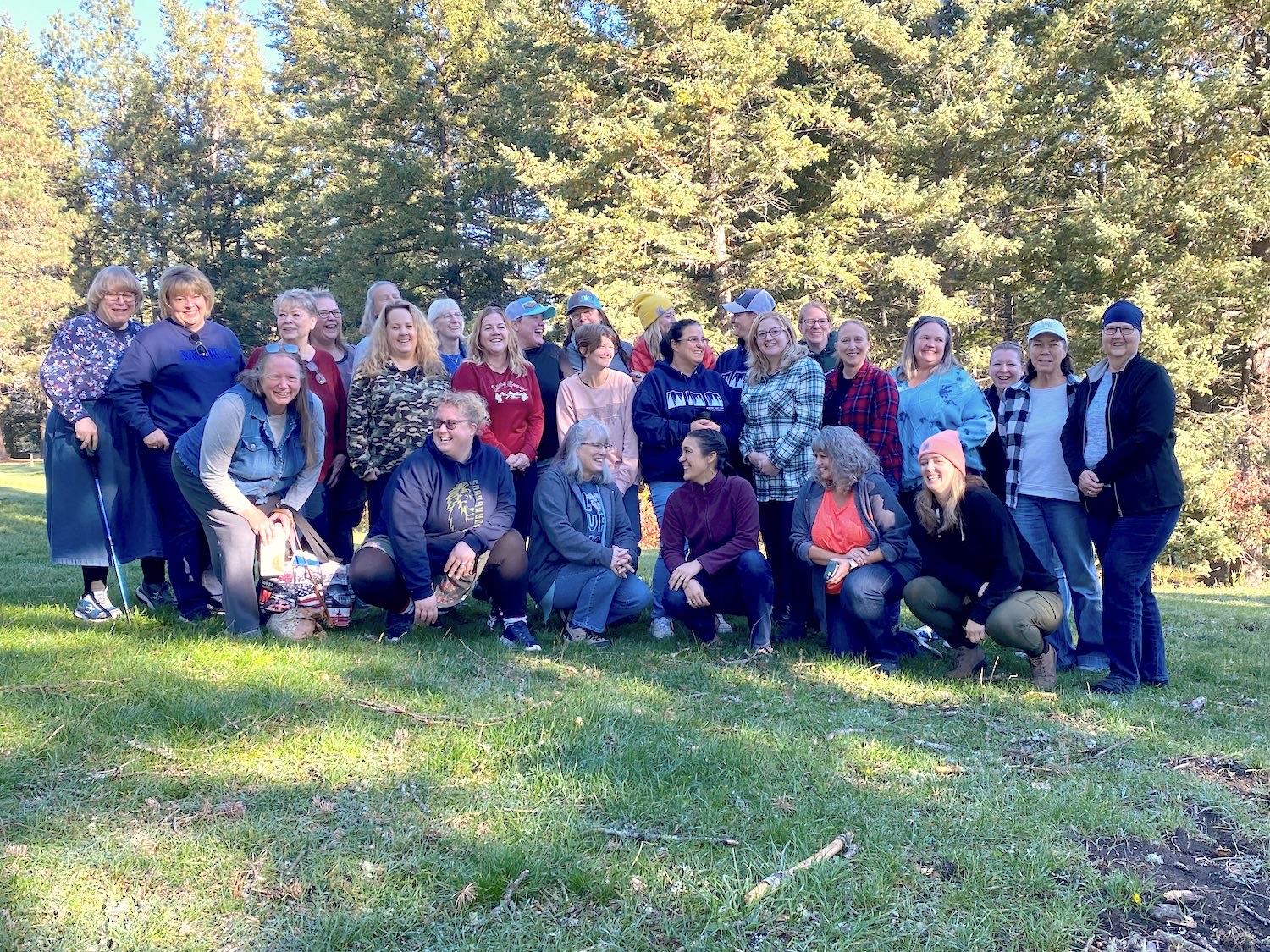 The women of Cornerstone gathered outdoors among the pines at their fall retreat